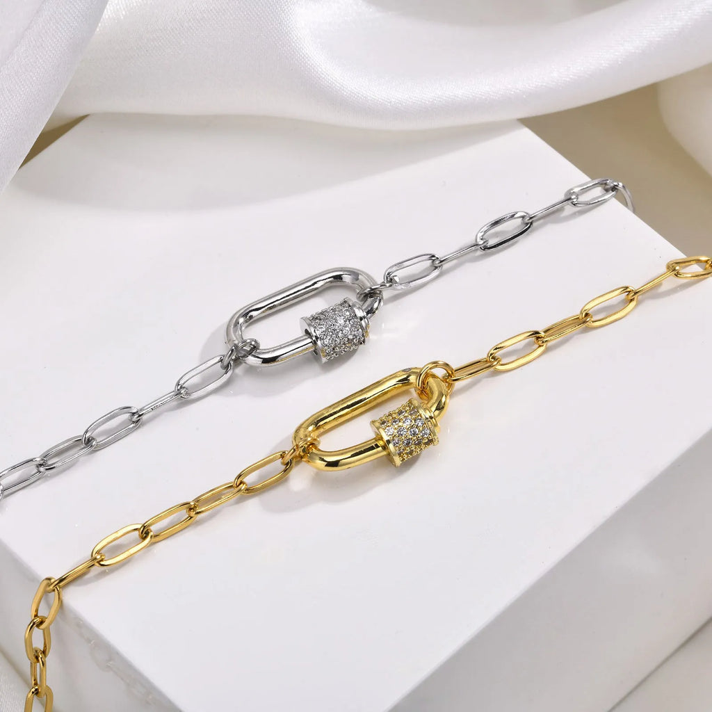 Gold electroplated stainless steel small square chain necklace with oval zircon pendant on a light background