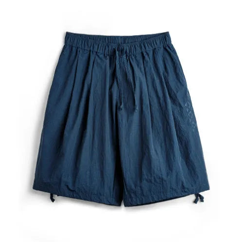 Men's loose-fit nylon beach shorts in Prussian blue colour with embroidered design details
