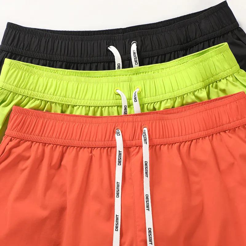 Men's loose beach shorts in polyester available in orange, green, and black colours