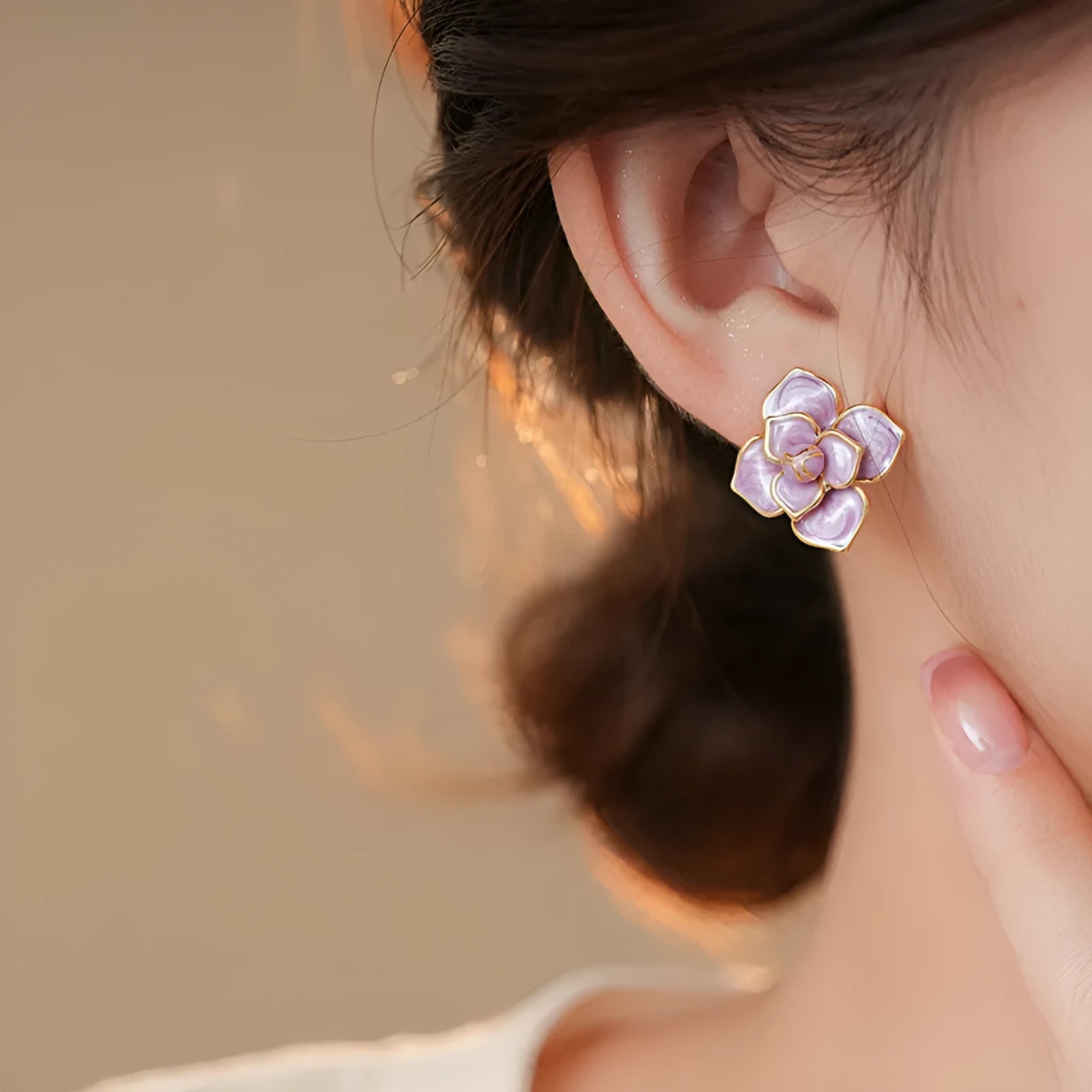 A pair of gold-plated flower stud earrings with a detailed purple oil-spot glaze finish on the petals.