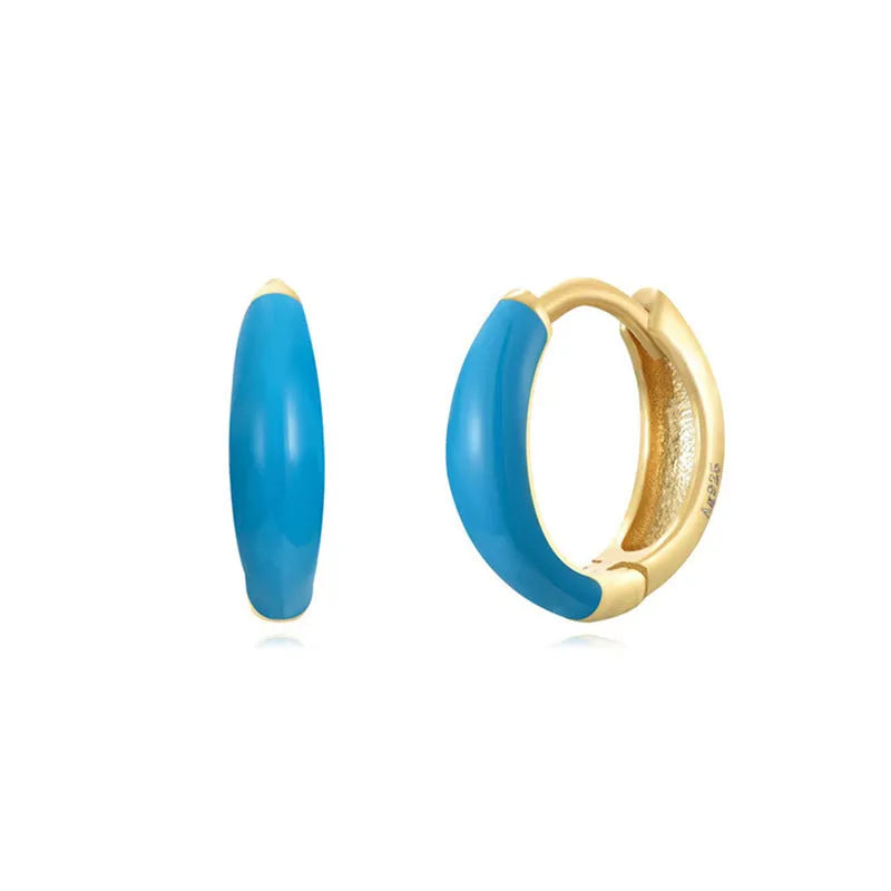 A pair of curved U-shaped epoxy earrings with a translucent blue dripped oil finish and a silver hook on a white background.