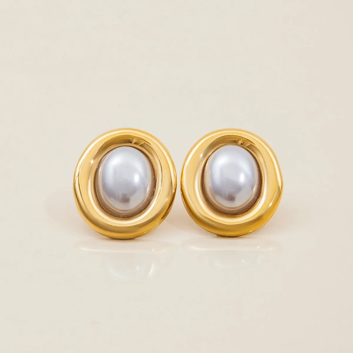 A pair of stainless steel vintage pearl stud earrings for women with a silver-toned finish and a fixed white pearl.