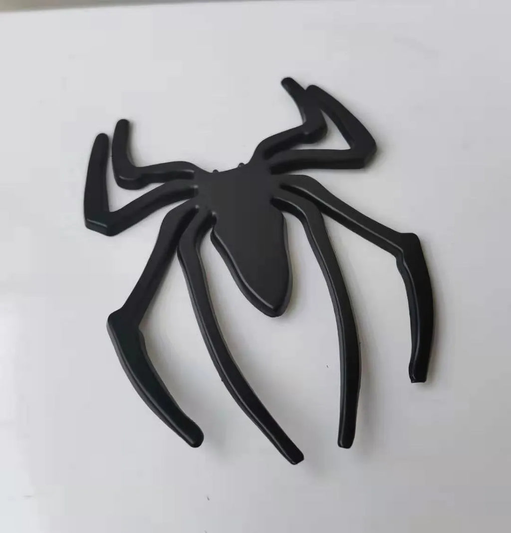 Three-dimensional metallic spider sticker in gold, silver, black, and red colours