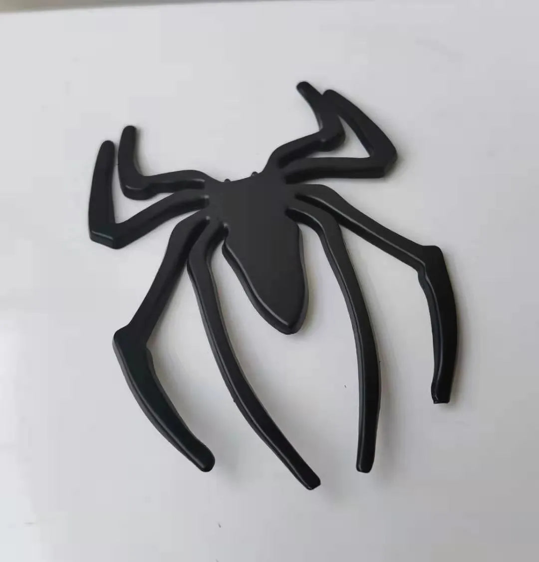 Three-dimensional metallic spider sticker in gold, silver, black, and red colours