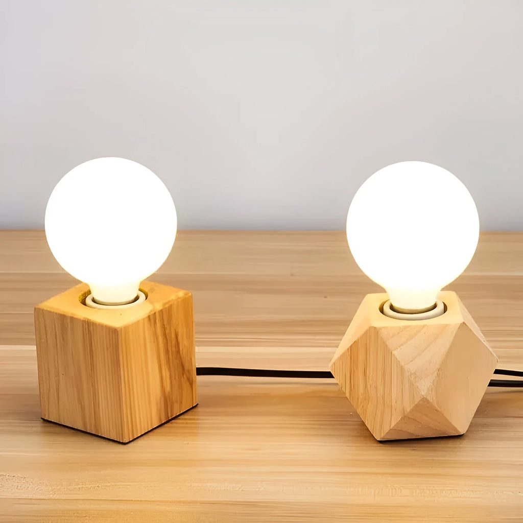 Retro-style square wooden lamp holder on a table next to a power cord.