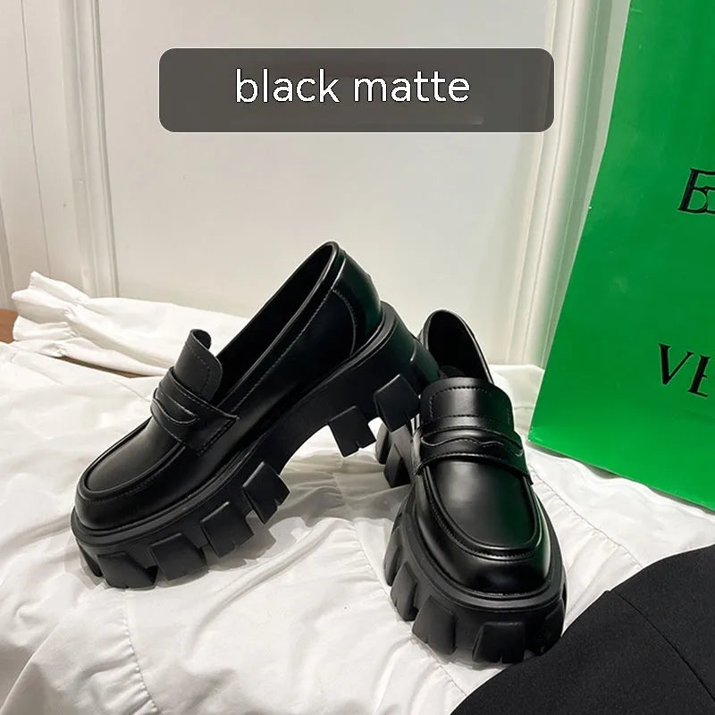 A pair of British style wide fit loafers in either matte or glossy patent leather with a shallow opening and rubber sole.