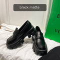 A pair of British style wide fit loafers in either matte or glossy patent leather with a shallow opening and rubber sole.