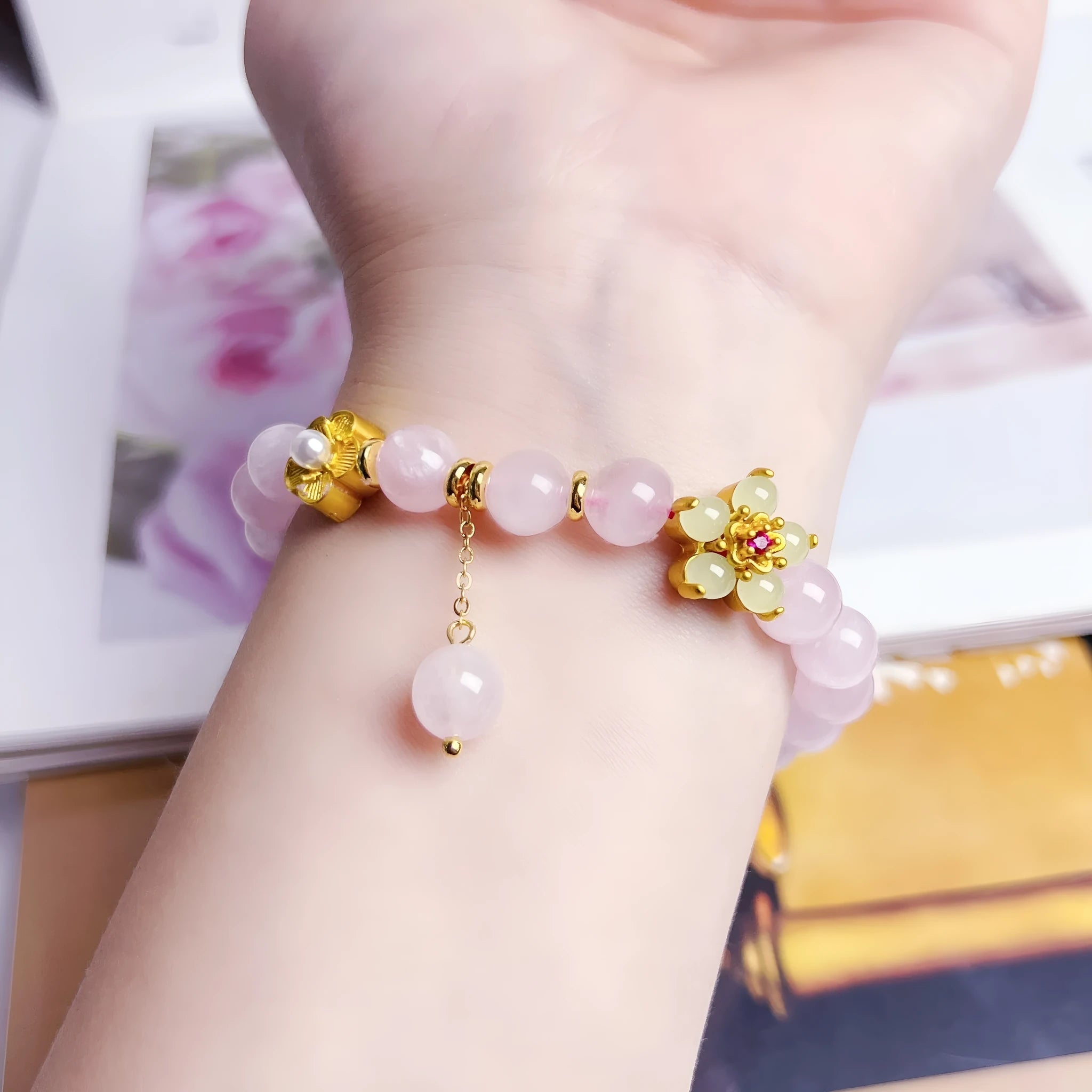 Pink crystal peach blossom bracelet with adjustable clasp on woman's wrist