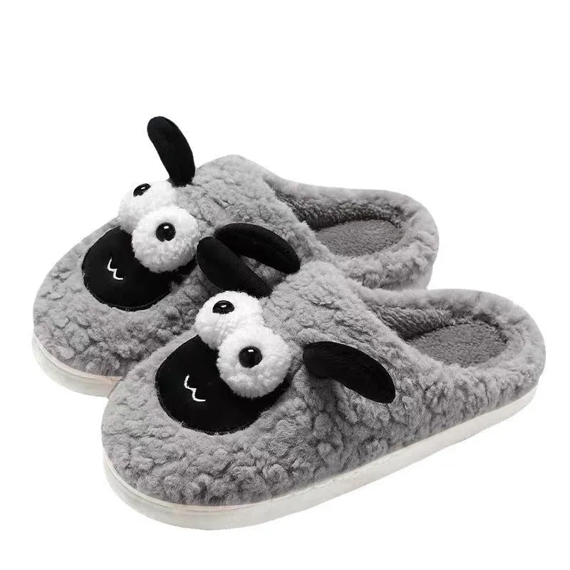 Brown suede slip-on slippers with a light-coloured PVC sole on a wooden floor.