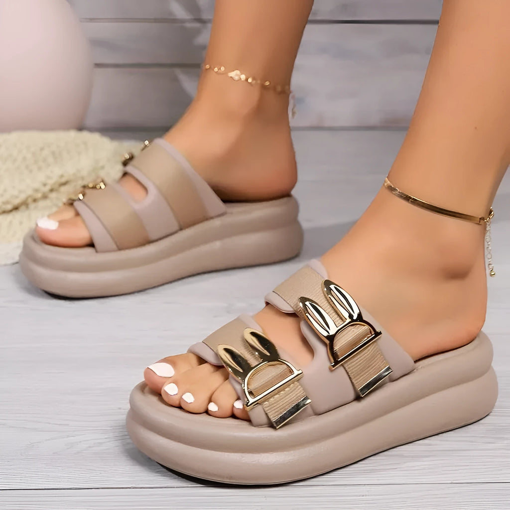 Women's apricot suede slippers with a thick, soft rubber sole on a light background.