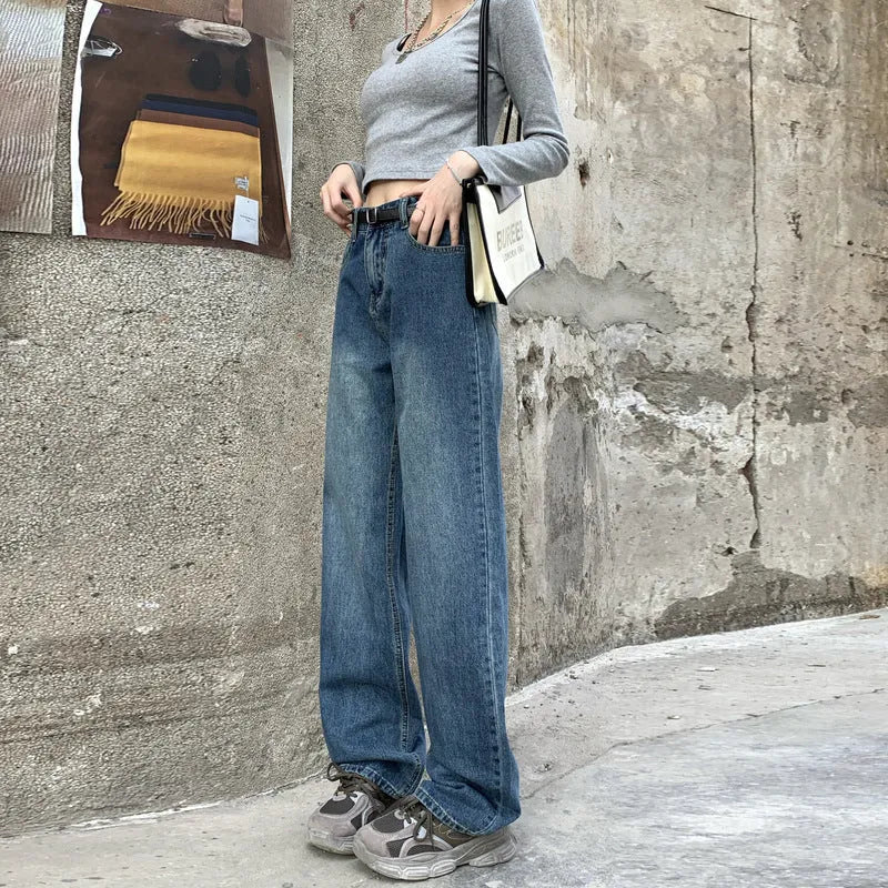 A woman wearing high-waist straight leg jeans in a retro blue colour, showcasing the classic denim fit.