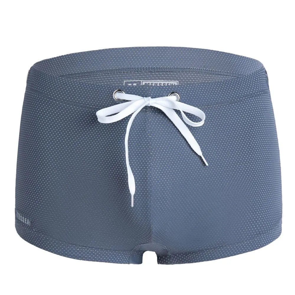 Men's solid colour lace nylon low waist swimming trunks on white background.