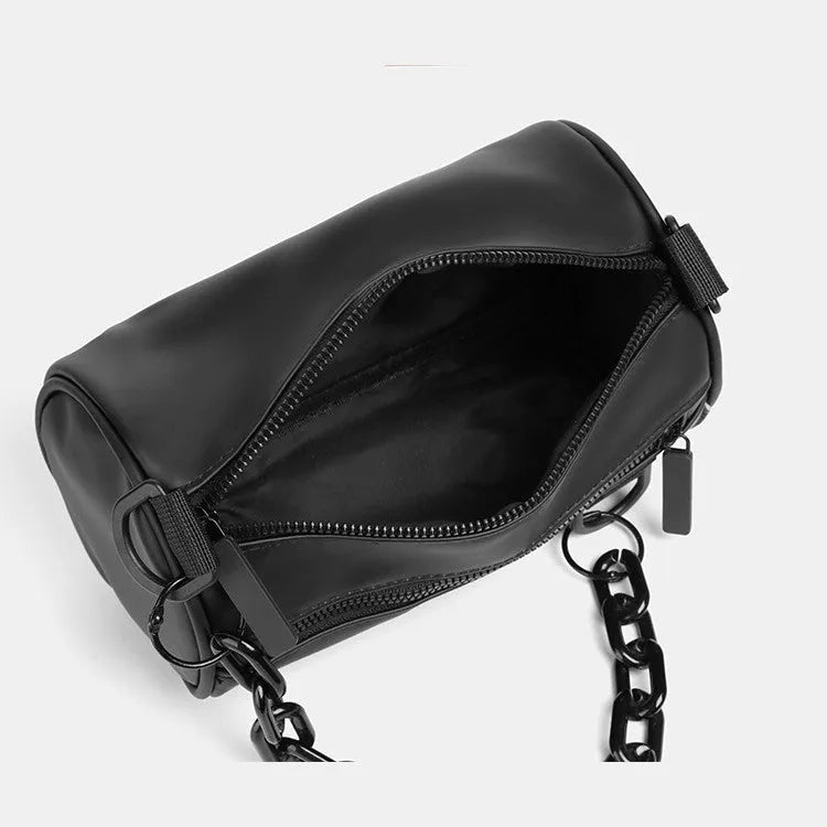 Black Oxford cloth messenger bag with a chain detail, worn crossbody.