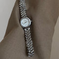 Women's thin 8mm alloy watch with white shell dial and gold strap on wrist