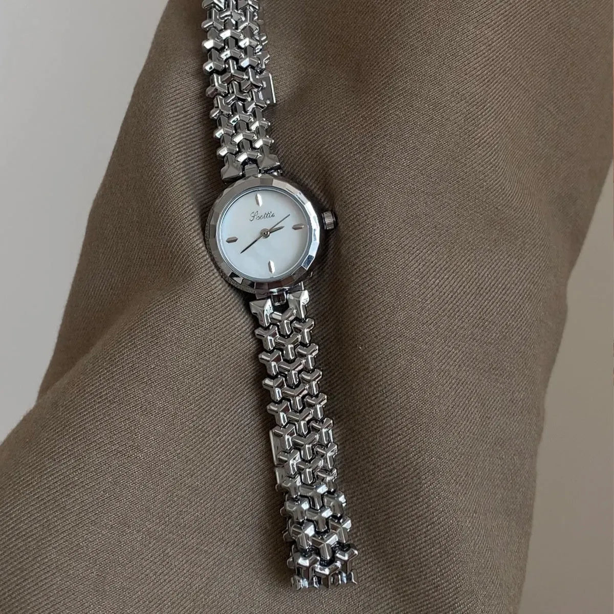 Women's thin 8mm alloy watch with white shell dial and gold strap on wrist