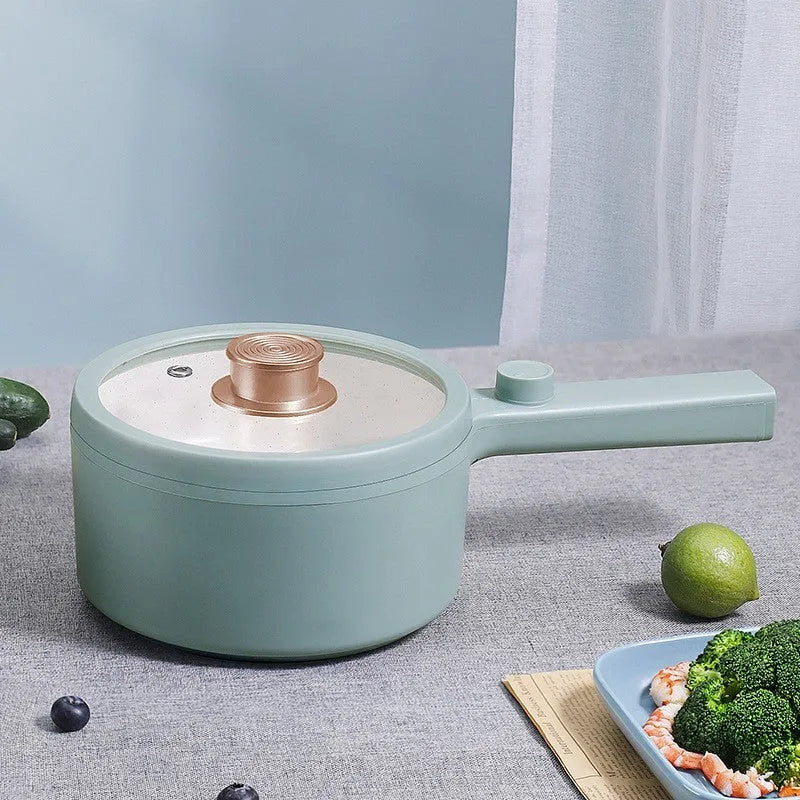 White and green multi-function electric cooking pot with temperature control dial and conversion plugs