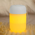 Small white cylindrical USB humidifier with aromatherapy diffuser on a wooden surface.