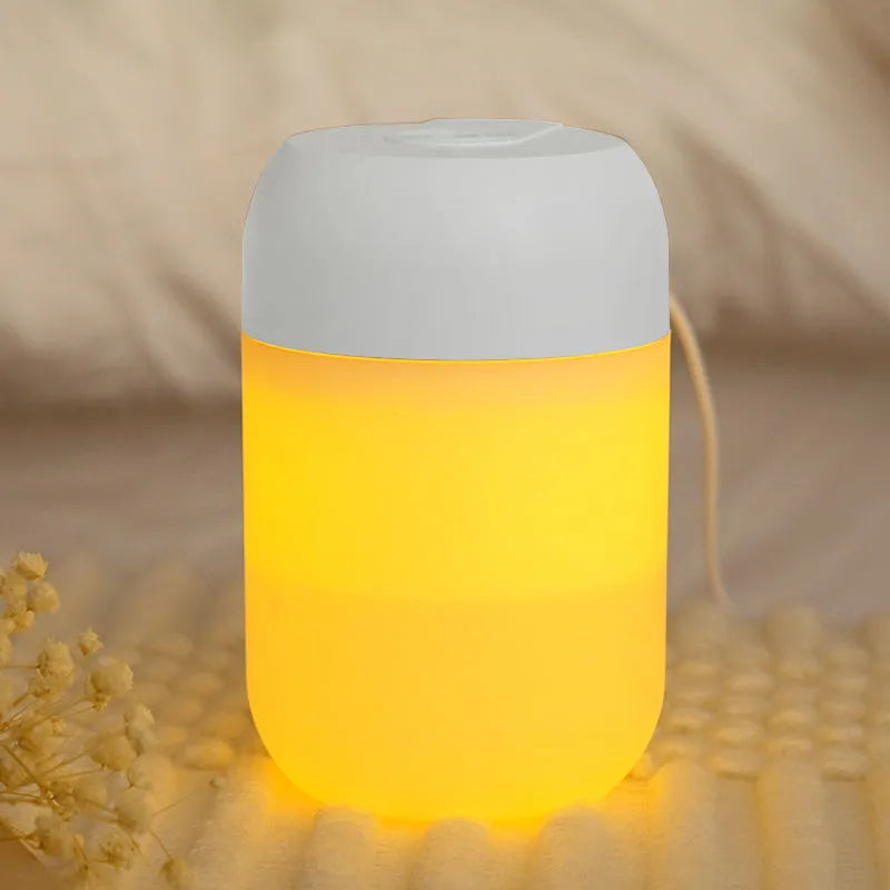 Small white cylindrical USB humidifier with aromatherapy diffuser on a wooden surface.