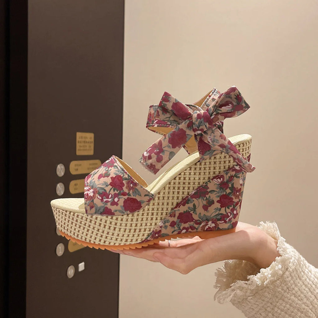 Women's wedge peep toe sandals with an ankle strap buckle in a floral pattern.