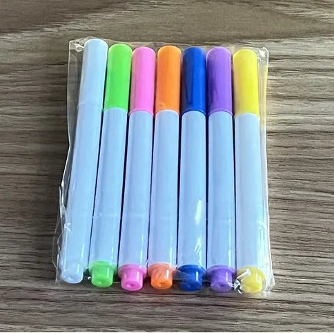 DIY acrylic LED message board on a desk with handwritten notes, glowing softly, next to colourful pens.