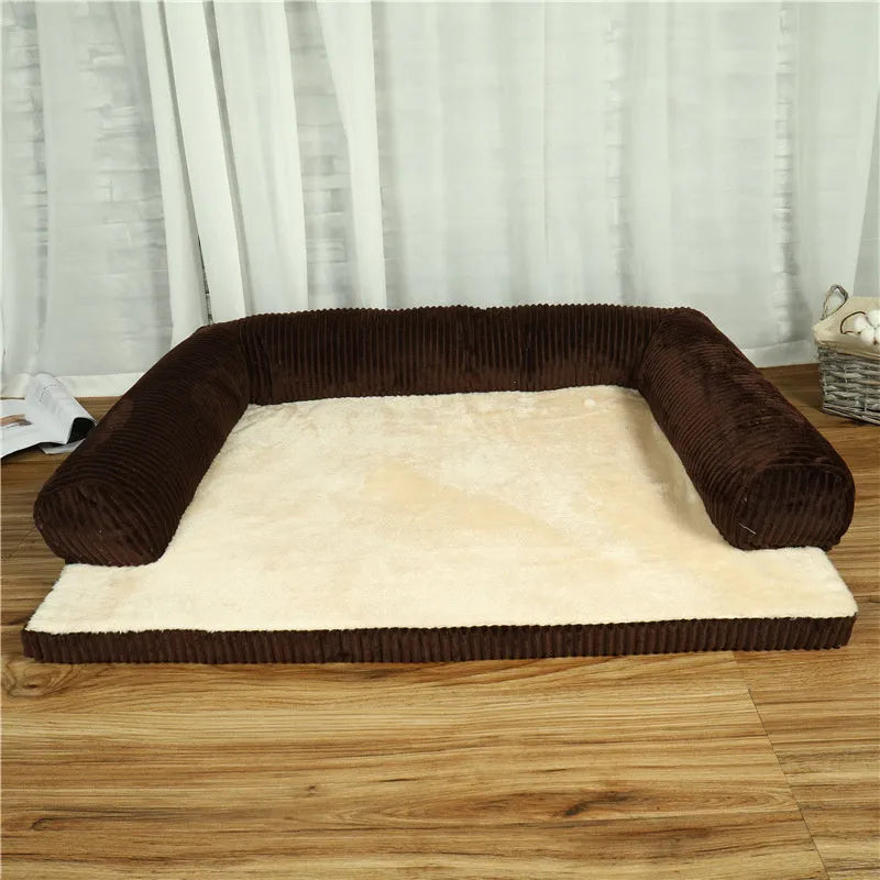 A corduroy dog sofa bed with a raised bolster side, shown in a grey colour on a wooden floor.