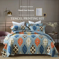 Quilted pure cotton bedspread with decorative stitching and a colourful printed pattern, shown with matching pillowcases on a double bed.