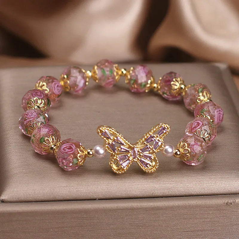 Pink crystal cherry blossom butterfly bracelet with hollow zircon accents on white background