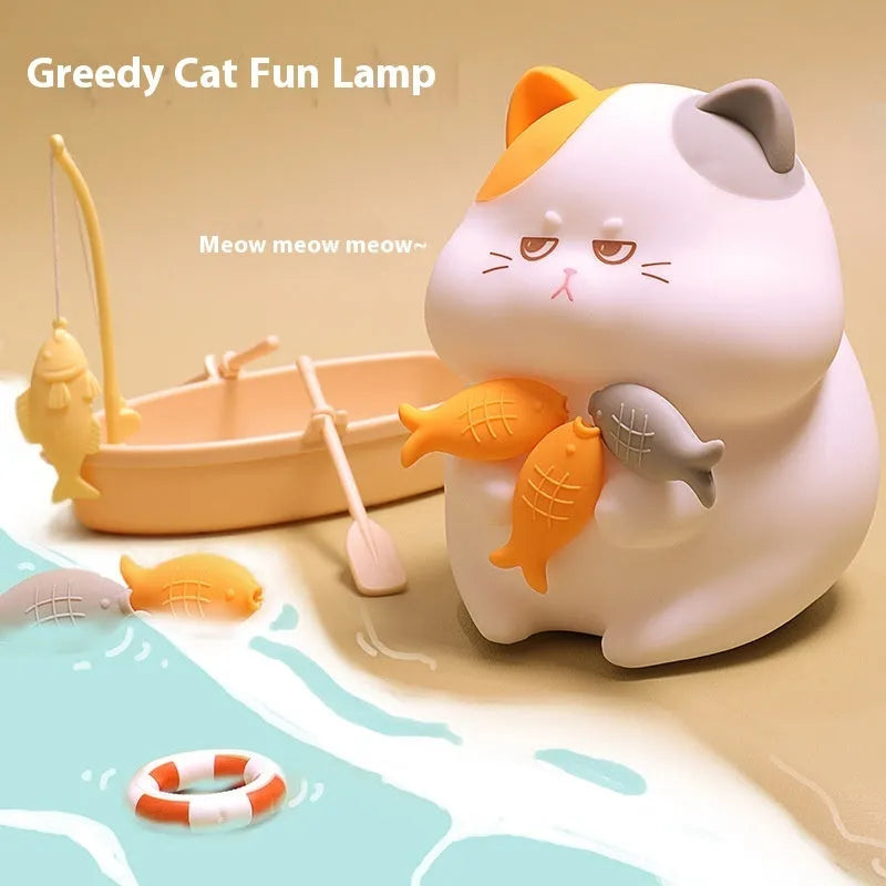 Yellow Greedy Cat cartoon desktop night light with USB cable on a wooden desk.