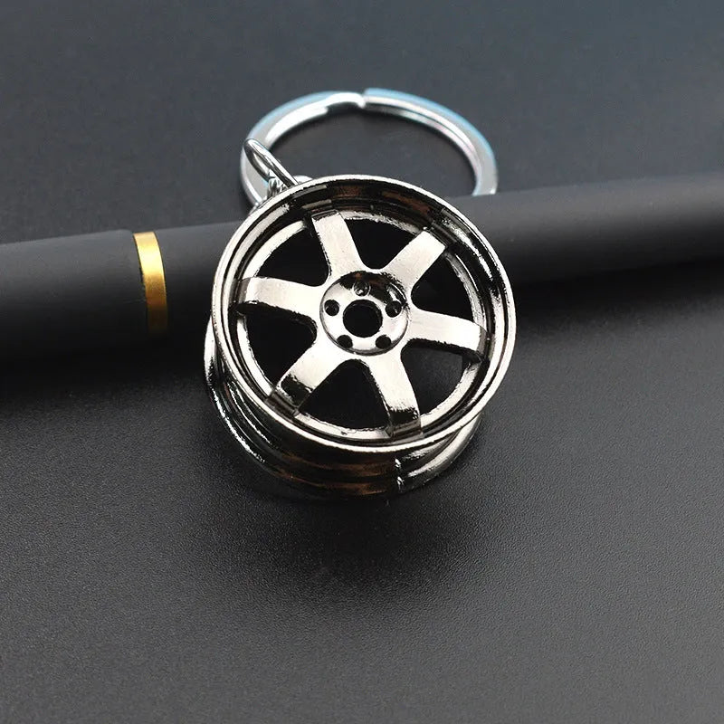 Zinc alloy car wheel hub keychain in gold, silver, and black colour options.