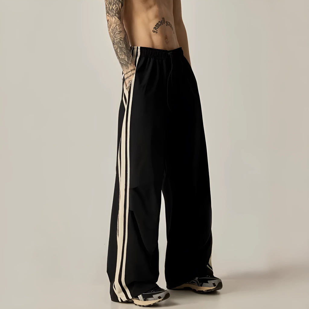 Black men's wide-leg climbing trousers with a high waist on a hanger.