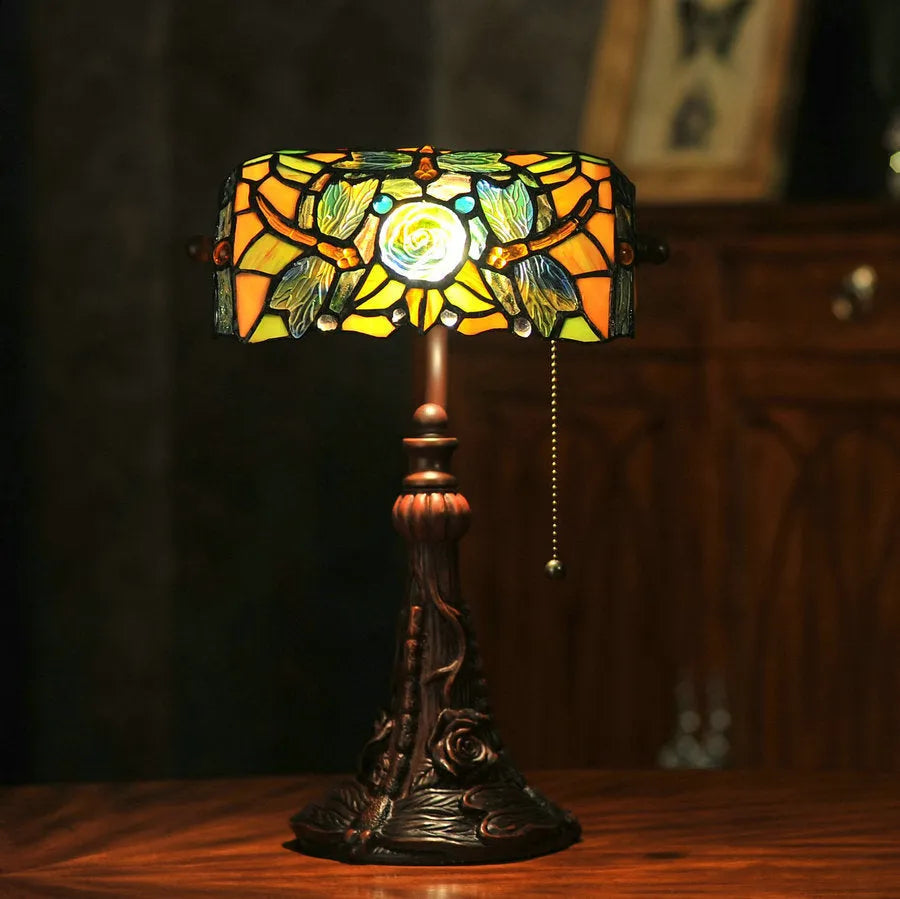 A 10-inch tall Tiffany-style table lamp with a stained glass shade on a resin base, shown on a desk.