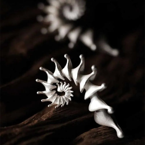 A pair of alloy conch-coloured stud earrings with an irregular three-dimensional shape and a matte finish.