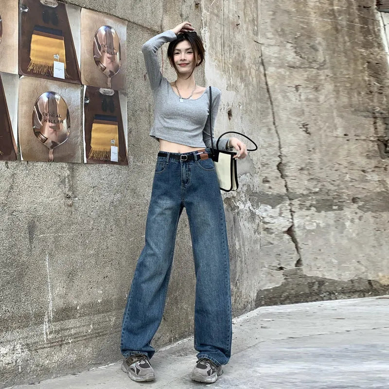 A woman wearing high-waist straight leg jeans in a retro blue colour, showcasing the classic denim fit.