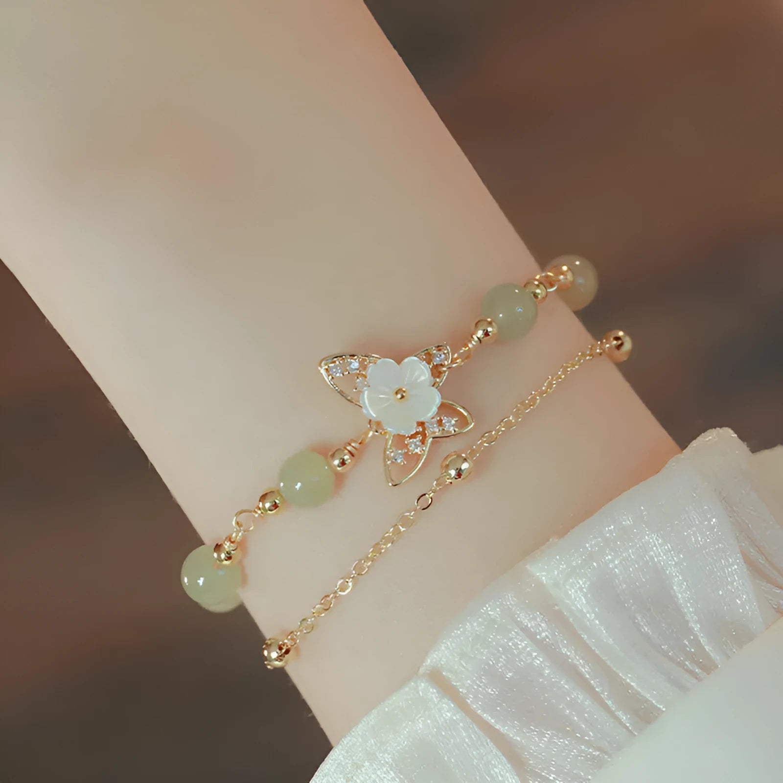 Yellow gold electroplated butterfly bracelet with shell flower design and Hetian jade accents on geometric copper jewellery