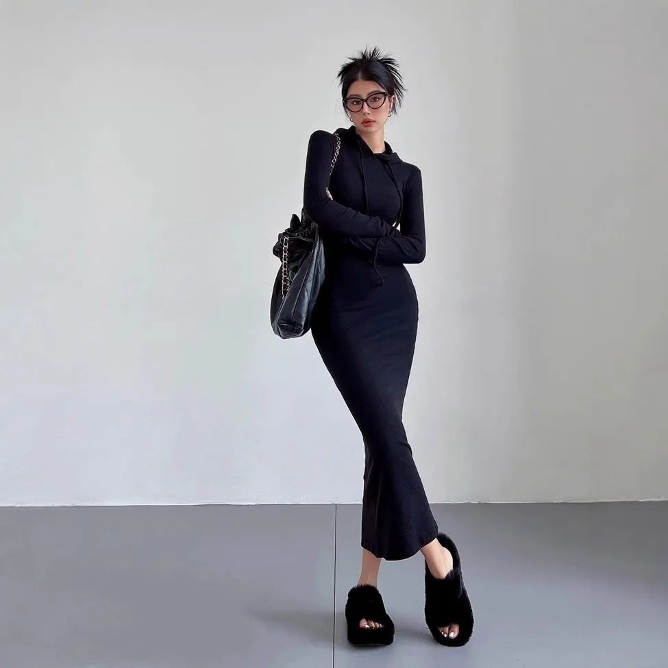 A woman modelling a grey hooded long-sleeve sheath dress with a high waist.