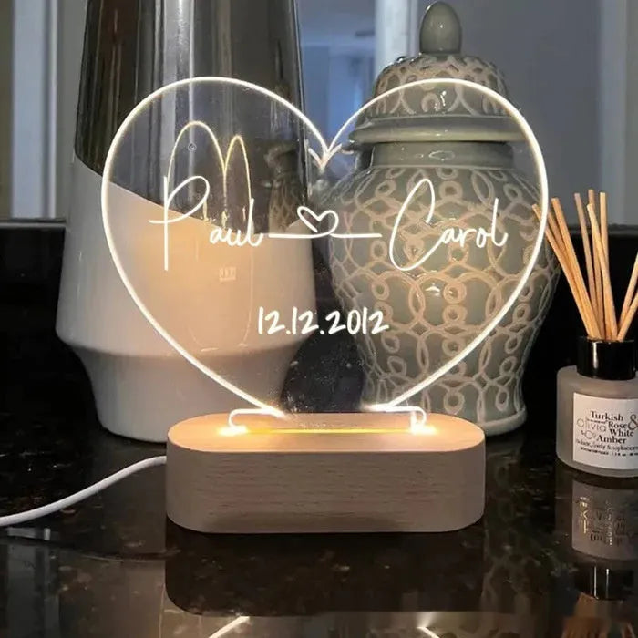 Custom clear acrylic night light displaying personalised names and date, lit by an LED base.