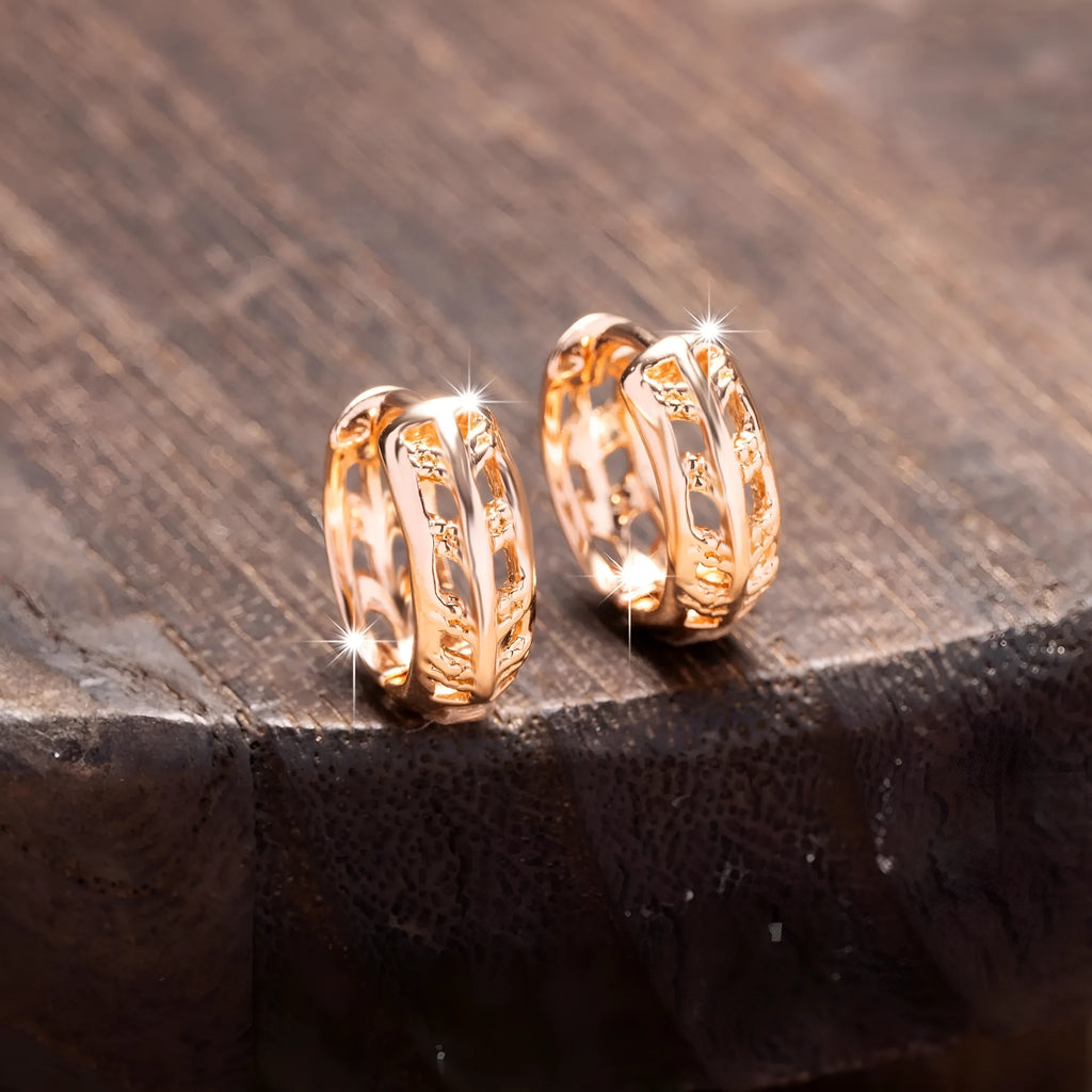 Rose gold plated hollowed-out heart and leaf shaped earrings on a white background.