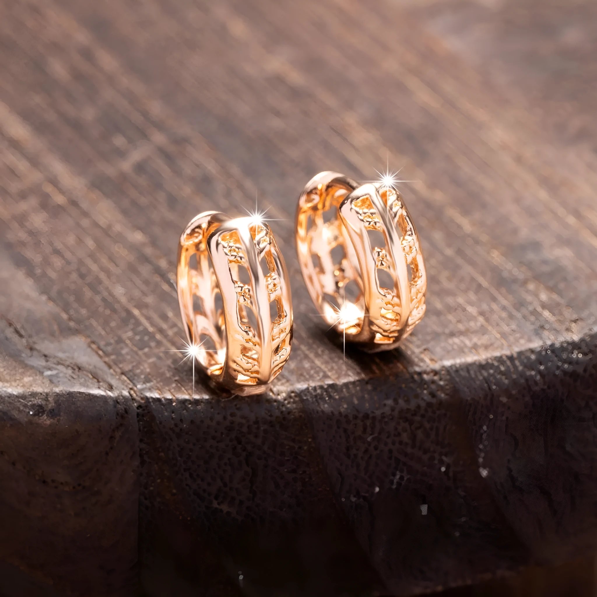 Rose gold plated hollowed-out heart and leaf shaped earrings on a white background.