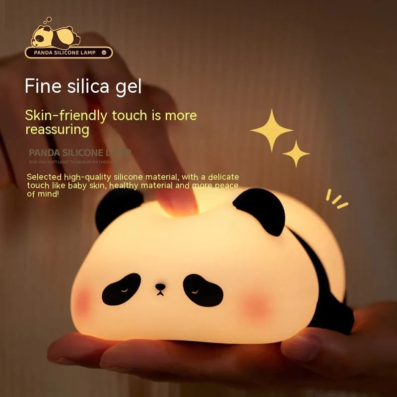 Cartoon panda head shaped silicone night light for children on a bedside table.
