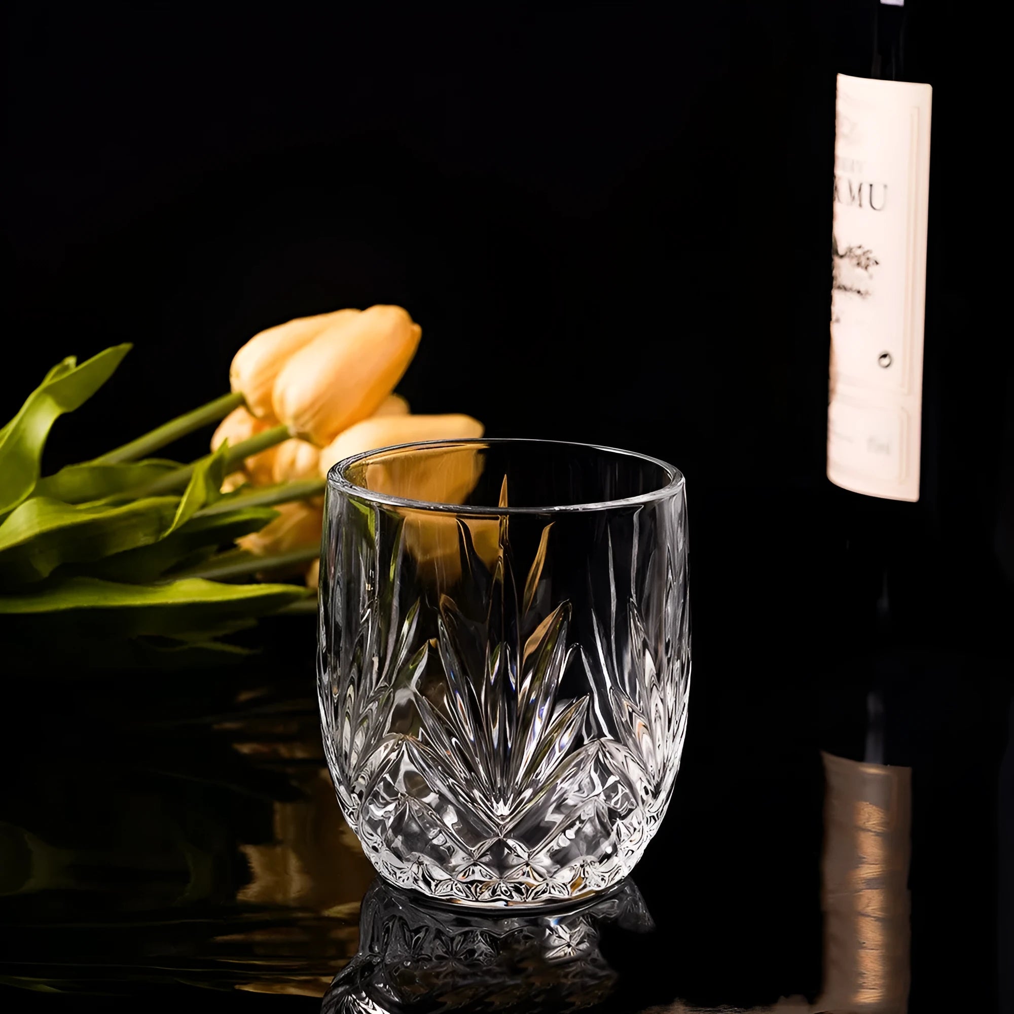 Clear crystal whiskey shot glass with thick bottom base on a table.