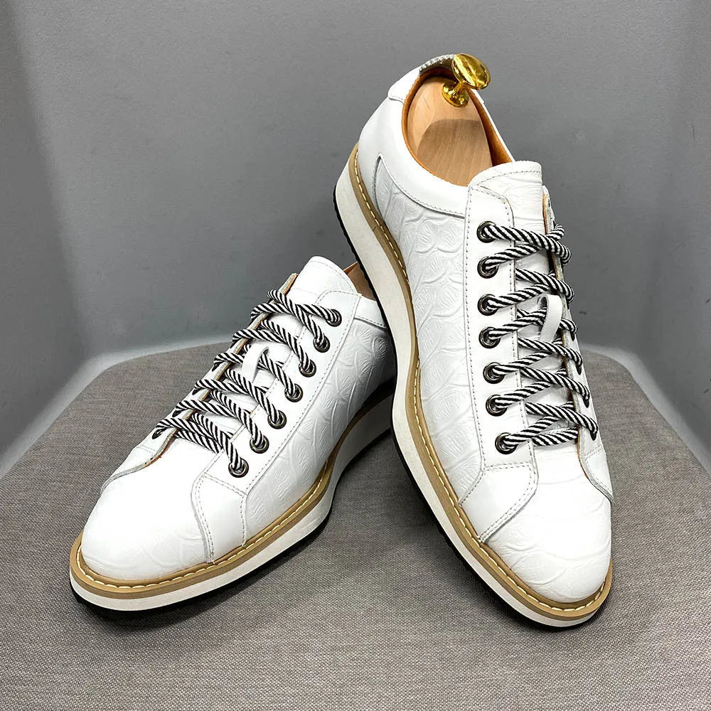 Men's low-top handmade shoes with embossed pattern on front, showing front-tie laces and grey colour.