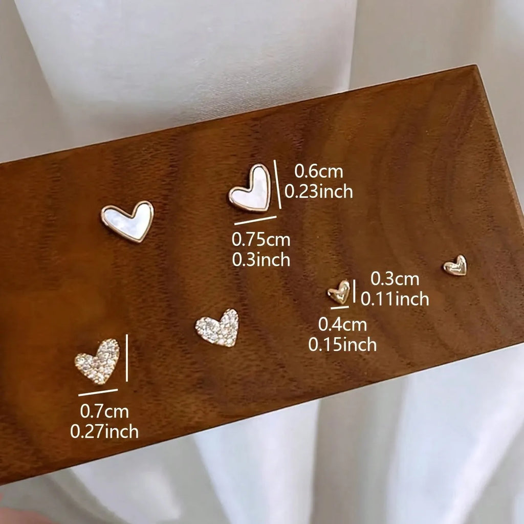 Three pairs of heart-shaped alloy earrings in gold, black, pink, and black-white colours