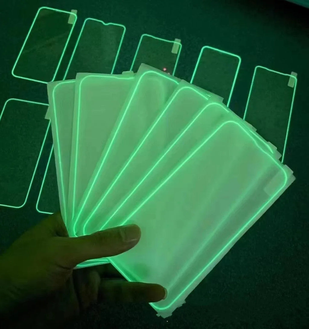 Fluorescent blue tempered glass screen protector glowing on an iPhone 13 in a dark setting.