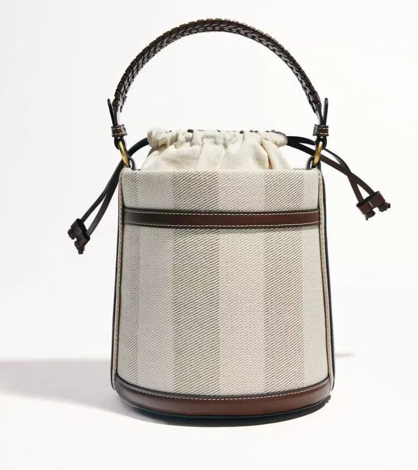 Brown PU leather bucket bag with woven texture, dual handles, and contrast stitching on a neutral background