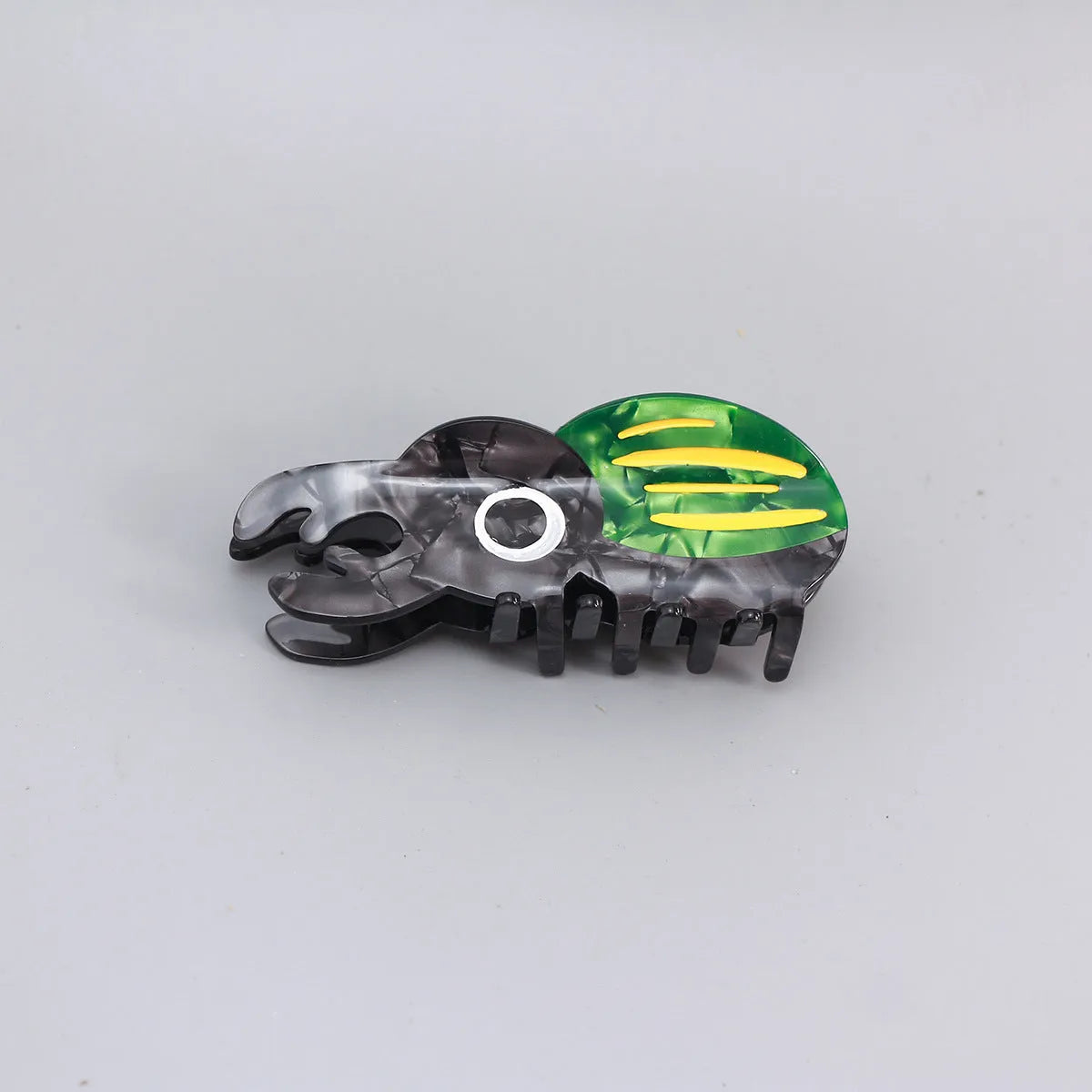 Handmade green cartoon beetle grip made from cellulose acetate sheet holding papers.