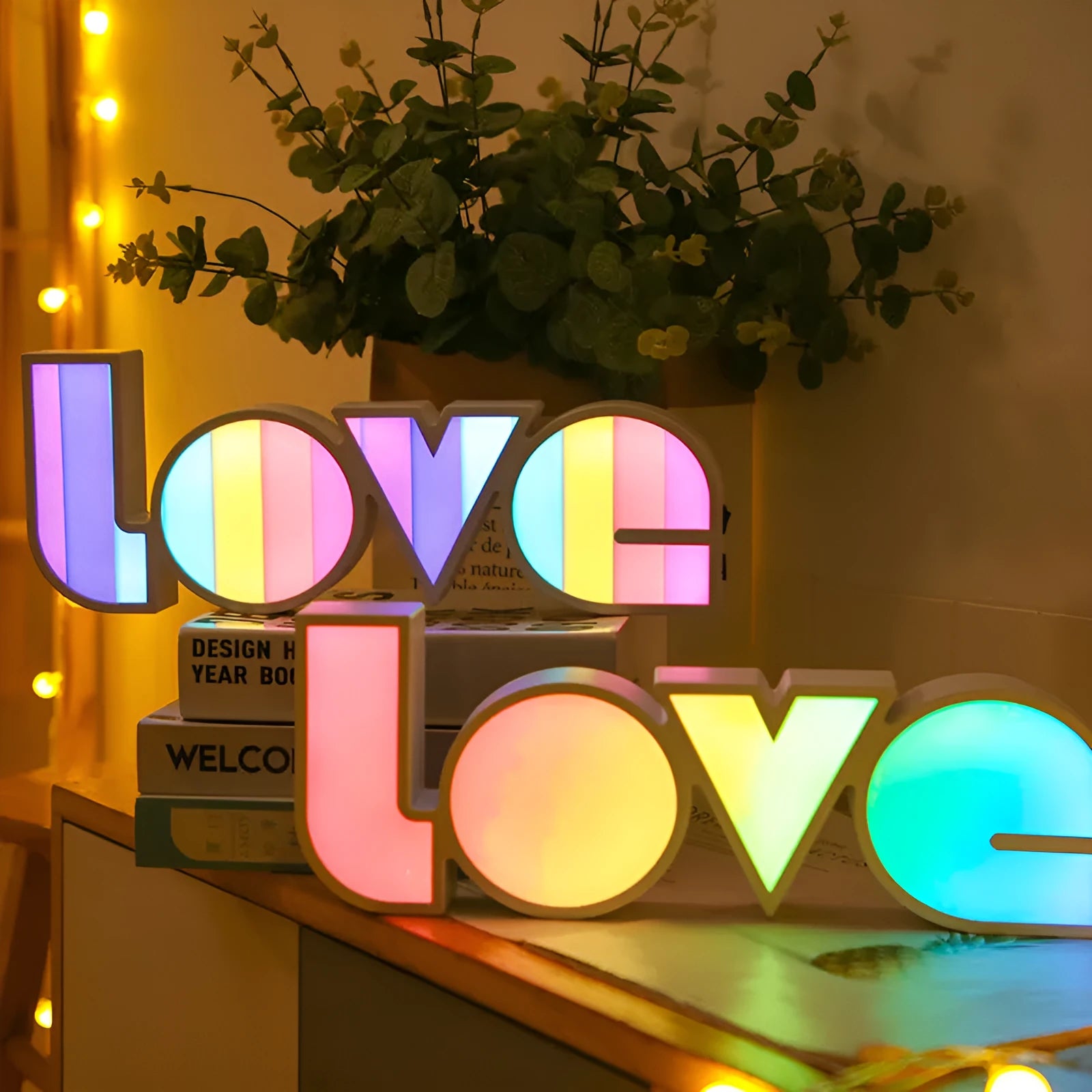 Rainbow coloured LED LOVE word light for Valentine's Day and wedding decoration on a table.