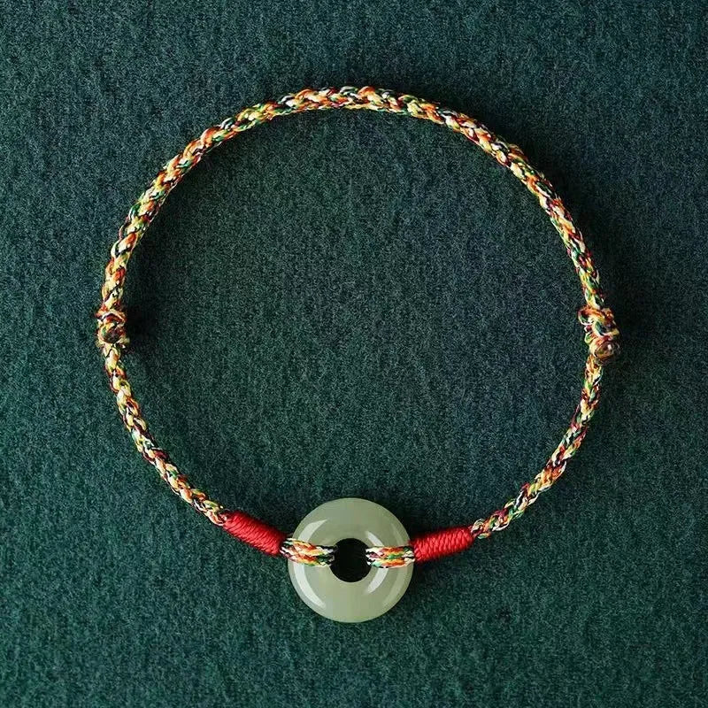 Colourful braided rope bracelet with peace buckle closure showing woven texture
