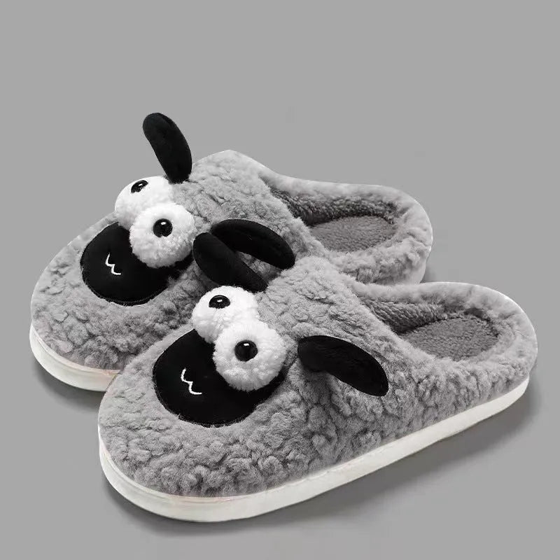 Brown suede slip-on slippers with a light-coloured PVC sole on a wooden floor.
