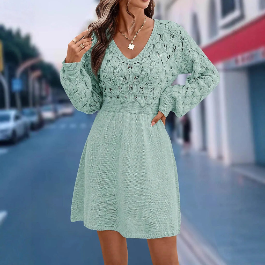A high-waisted, long-sleeve v-neck dress with a 3D pattern in a light blue green colour.