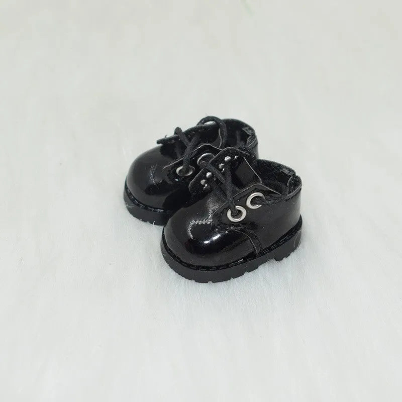 A pair of 17 cm high black doll shoes made from PU leather, shown as a keychain accessory.
